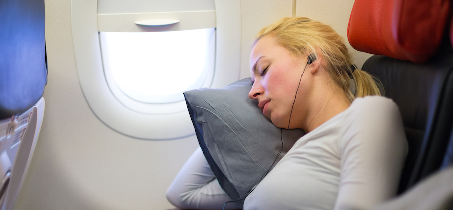 Blonde woman sleeping on plane in Mind Your Own Business Class.