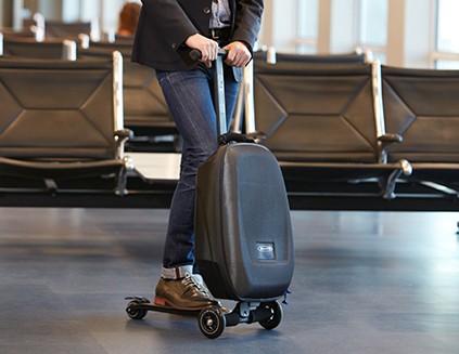 Man riding carryon bag scooter