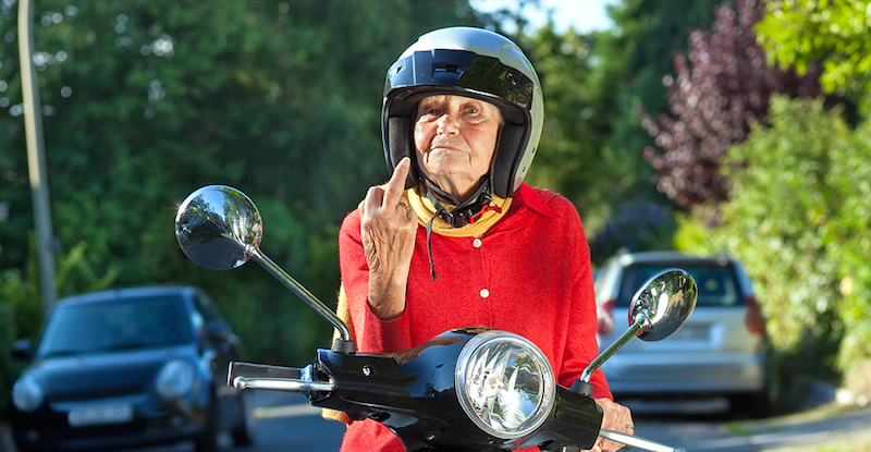 Visitor's guide America. Senior woman on scooter showing road rage