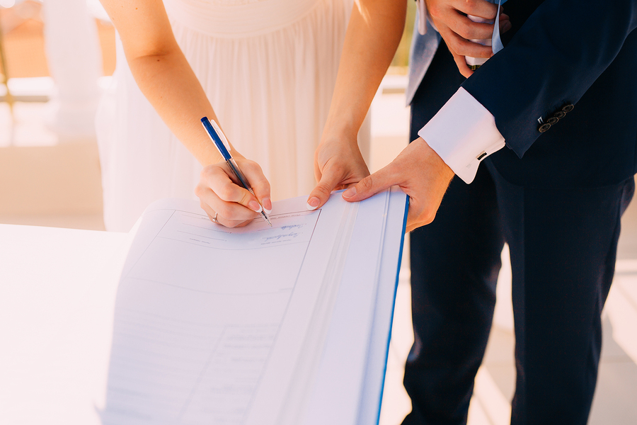 bride and groom sign wedding document